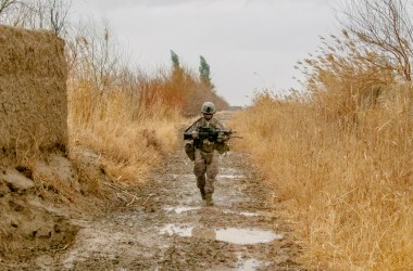 A Marine from the author's squad walks down a muddy goat trail on patrol in Marjah during the spring of 2011.