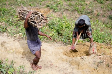 A Rohingya boy chopping wood from a tree stump he freed from soil near Kutupalong-Balukhali refugee camp in Bangladesh.